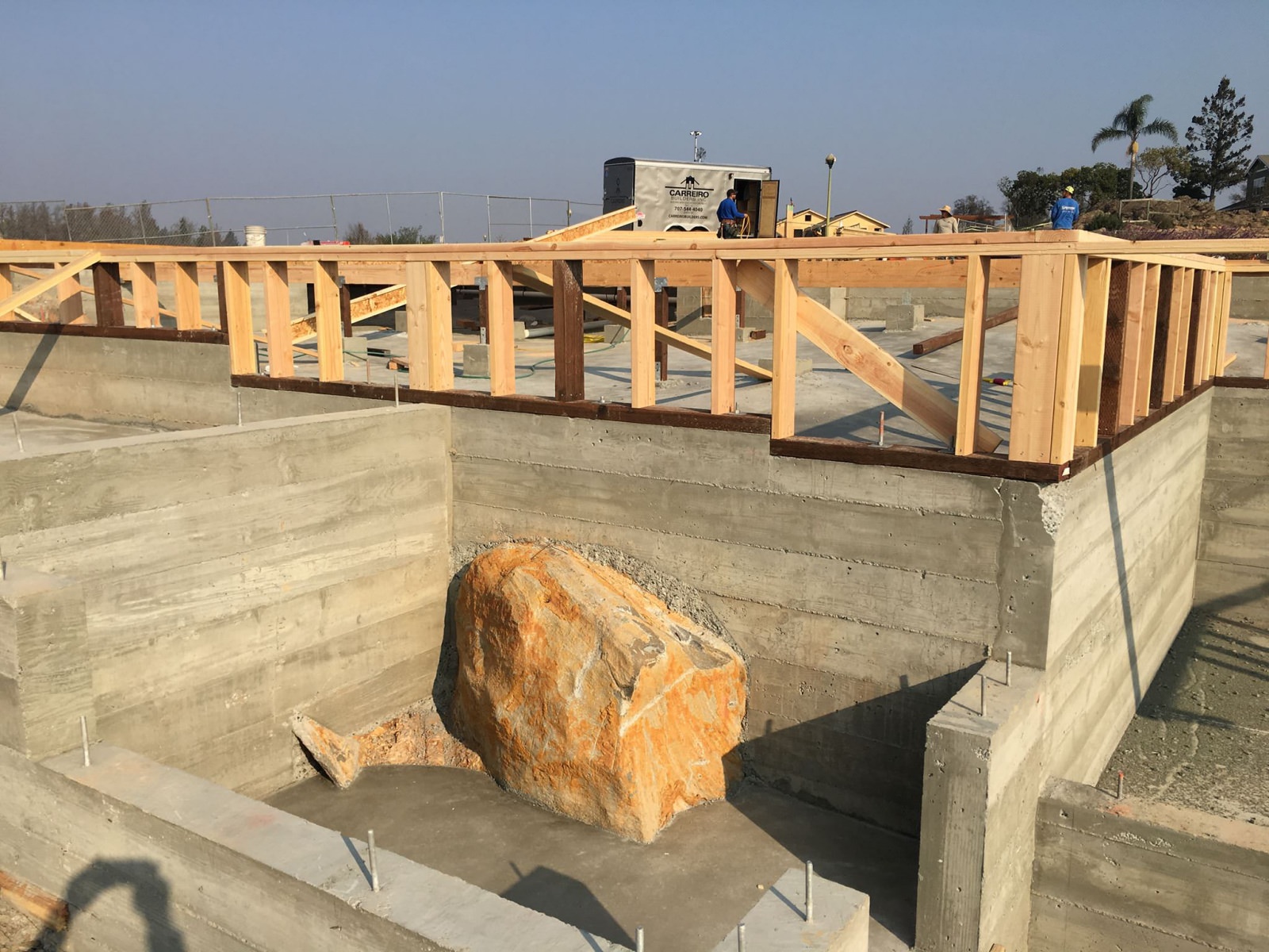concrete wall built around a large stone